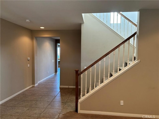 stairway featuring tile patterned flooring and a healthy amount of sunlight