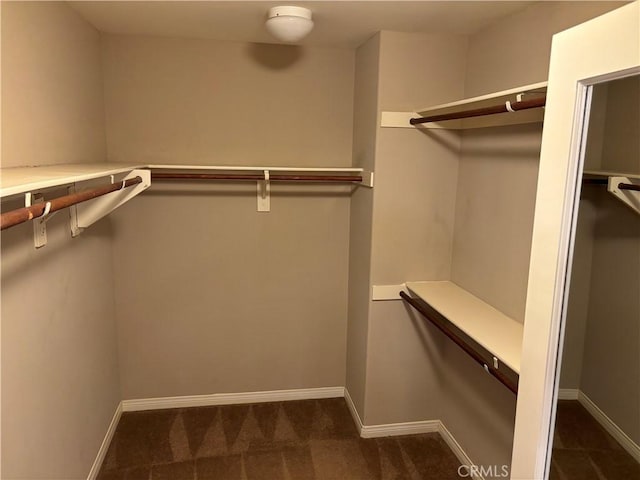 spacious closet featuring dark carpet