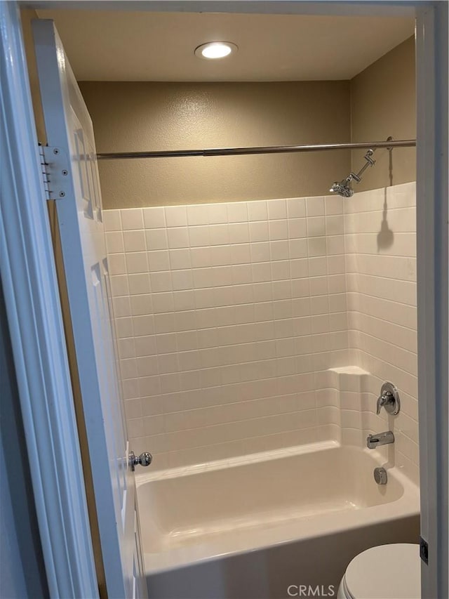 bathroom with tiled shower / bath and toilet