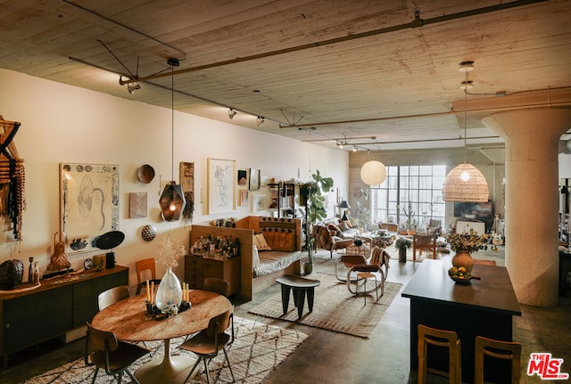 dining area with concrete floors and track lighting