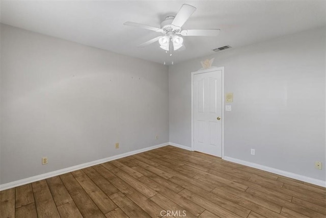 unfurnished room with baseboards, a ceiling fan, visible vents, and light wood-style floors