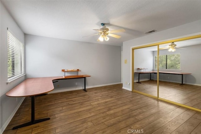 office area with visible vents, wood finished floors, a ceiling fan, and baseboards