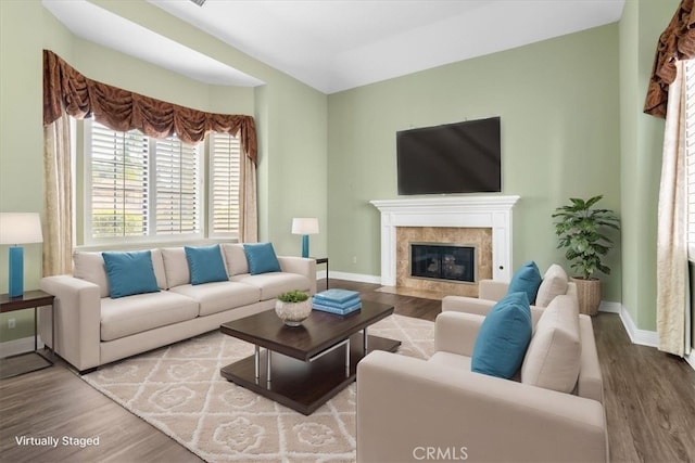 living room with a high end fireplace and wood finished floors