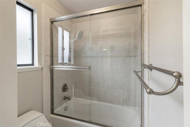 full bath featuring bath / shower combo with glass door and toilet