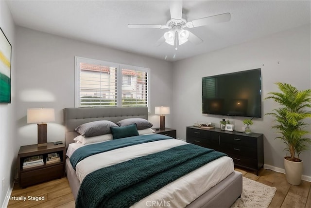 bedroom with light wood-style floors, baseboards, and a ceiling fan