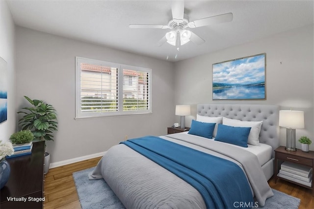 bedroom with baseboards, dark wood finished floors, and a ceiling fan