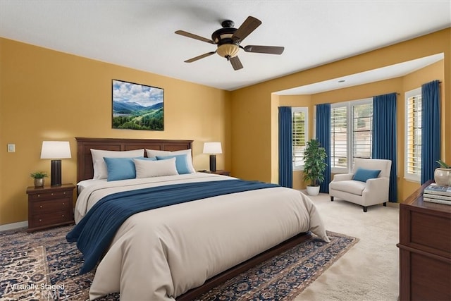 bedroom featuring light carpet, baseboards, and a ceiling fan