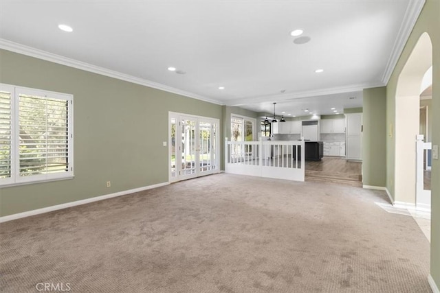 unfurnished living room with carpet, baseboards, crown molding, and recessed lighting