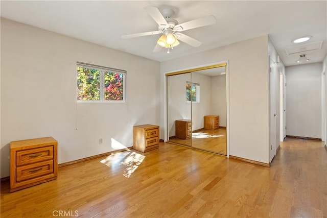 unfurnished bedroom with ceiling fan, a closet, and light hardwood / wood-style floors