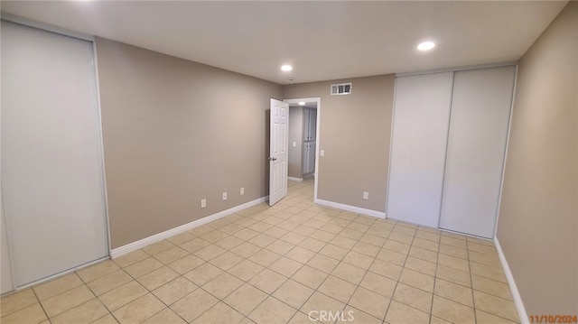 empty room with recessed lighting, visible vents, and baseboards