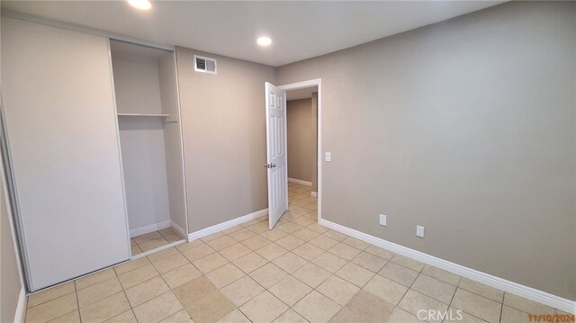 unfurnished bedroom featuring light tile patterned floors, baseboards, visible vents, recessed lighting, and a closet