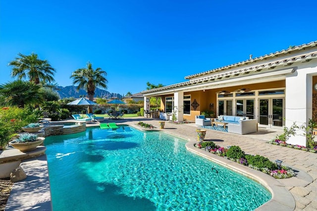 view of pool featuring outdoor lounge area, a patio, ceiling fan, and an in ground hot tub