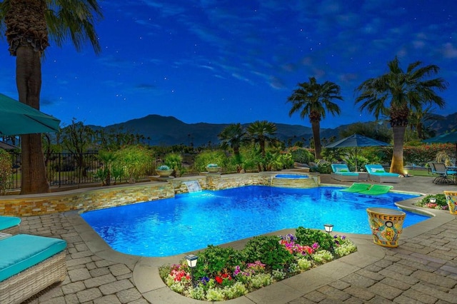 view of swimming pool with an in ground hot tub, a mountain view, and a patio area