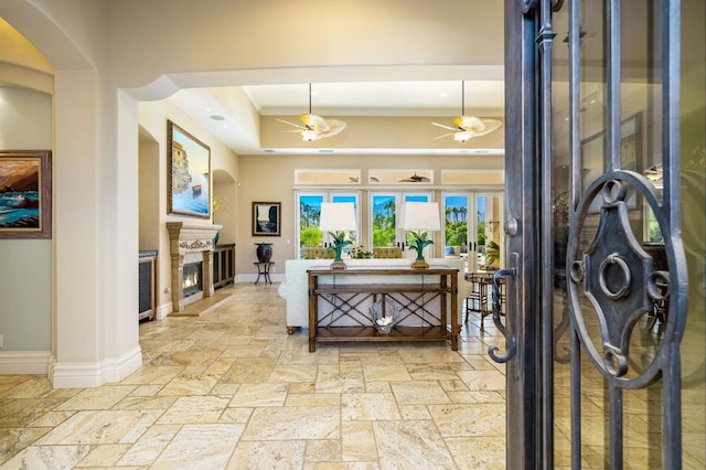 foyer with crown molding, ceiling fan, and a towering ceiling