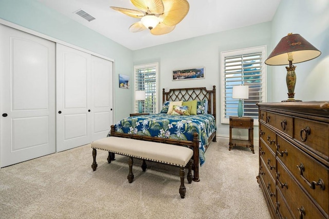 carpeted bedroom featuring ceiling fan and a closet