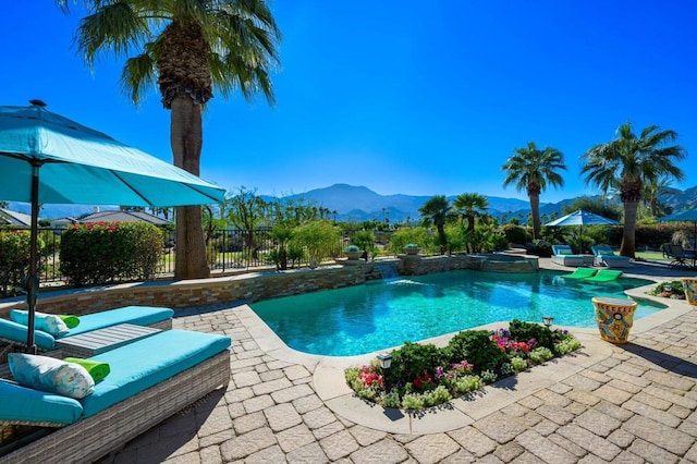 view of pool with a mountain view, a patio area, and pool water feature