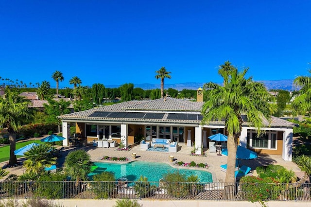 back of house with a fenced in pool and a patio area