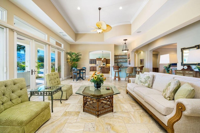 living room featuring crown molding, french doors, ceiling fan, and a towering ceiling