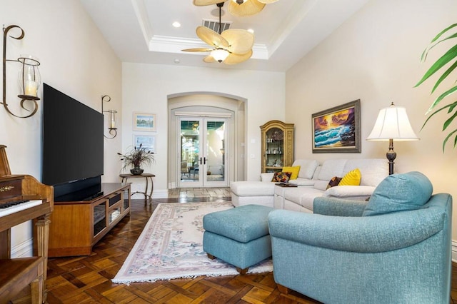 living room featuring french doors, ceiling fan, dark parquet flooring, and a tray ceiling