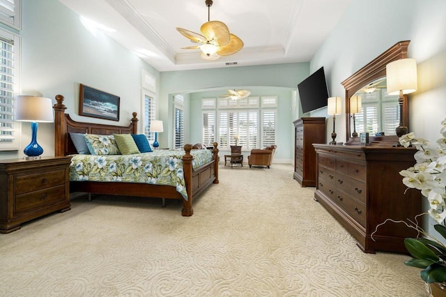 bedroom with multiple windows, crown molding, and a tray ceiling