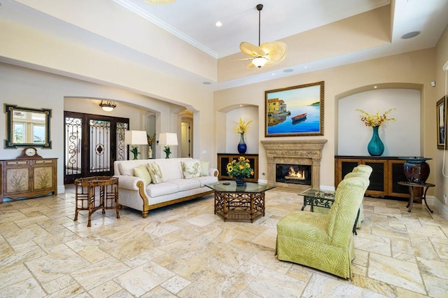 living room featuring a raised ceiling, ornamental molding, and a towering ceiling