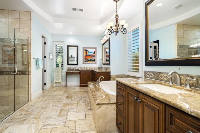 bathroom featuring a chandelier, vanity, a tray ceiling, and separate shower and tub