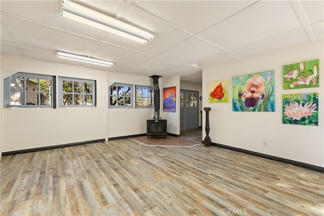 unfurnished room with a wood stove and hardwood / wood-style flooring