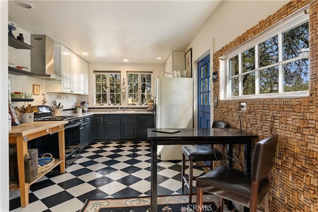 kitchen featuring gray cabinetry, black appliances, white cabinets, sink, and wall chimney exhaust hood