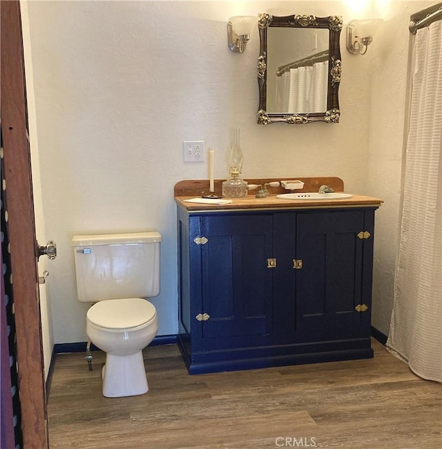 bathroom with vanity, toilet, and wood-type flooring