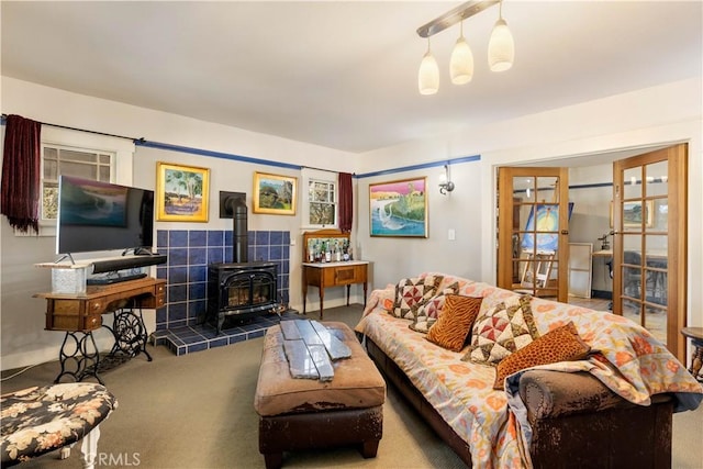 carpeted living room featuring french doors and a wood stove