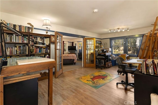 office with hardwood / wood-style flooring and french doors