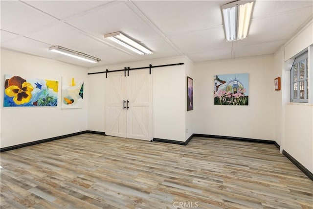 empty room featuring a barn door and light wood-type flooring