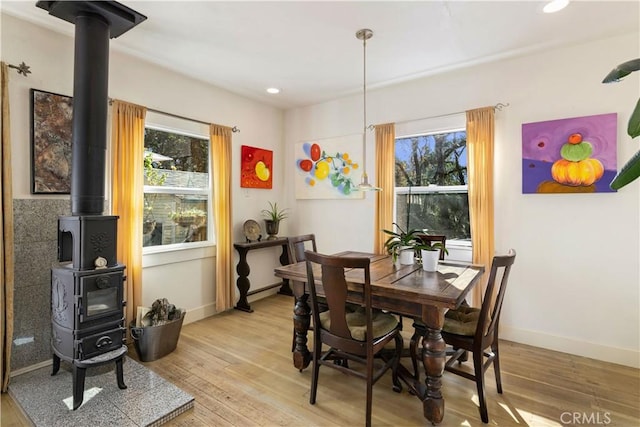 dining space featuring light hardwood / wood-style floors and a wood stove