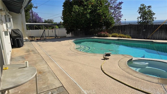 view of swimming pool with an in ground hot tub, area for grilling, and a patio area