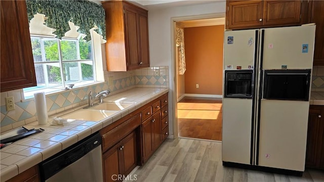 kitchen with stainless steel dishwasher, tasteful backsplash, white fridge with ice dispenser, and tile countertops