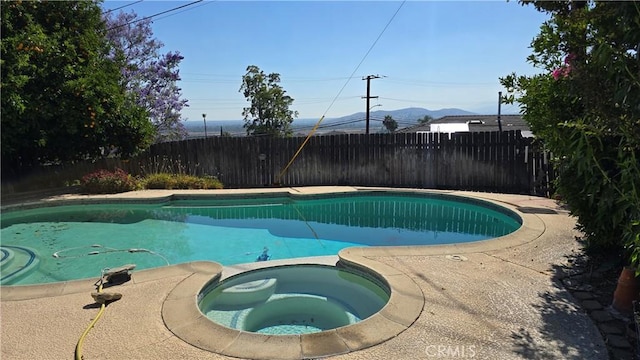 view of swimming pool featuring a mountain view and an in ground hot tub