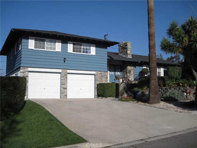 3930 Ironwood St, San Bernardino, CA 92404 - split level home with driveway, stone siding, a chimney, and an attached garage