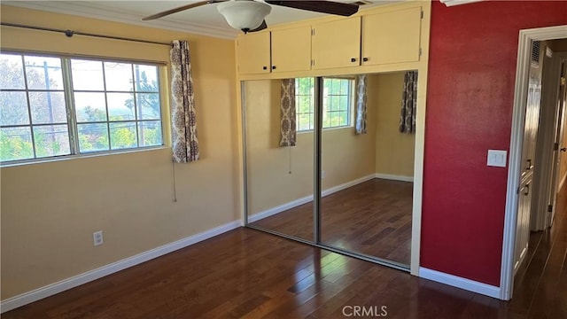 unfurnished bedroom featuring dark hardwood / wood-style floors, a closet, crown molding, and ceiling fan