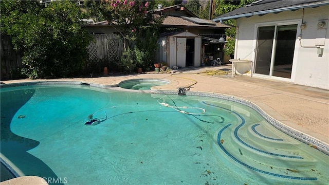 3930 Ironwood St, San Bernardino, CA 92404 - view of pool featuring an outdoor structure, an in ground hot tub, a patio area, fence, and a storage unit