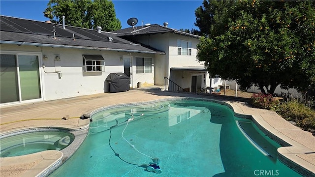 view of swimming pool featuring a grill, a patio area, and an in ground hot tub