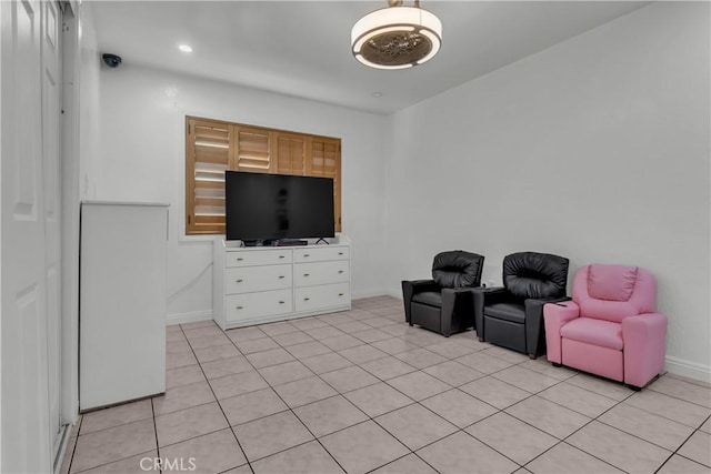 living area featuring baseboards and light tile patterned flooring