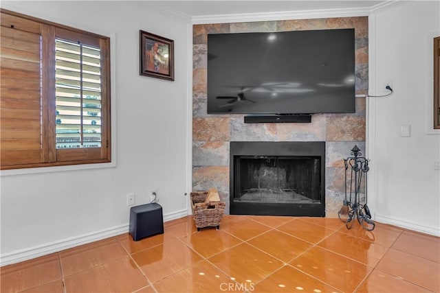 details featuring a ceiling fan, a tiled fireplace, baseboards, and crown molding