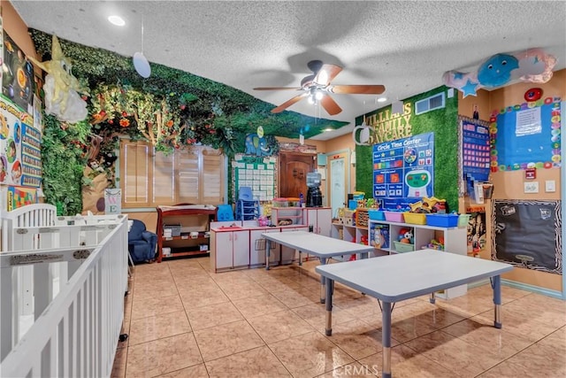 interior space featuring light tile patterned floors, ceiling fan, visible vents, and a textured ceiling