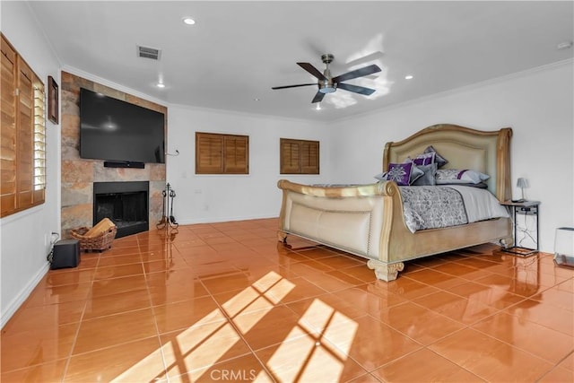 bedroom with a large fireplace, visible vents, baseboards, ornamental molding, and tile patterned flooring