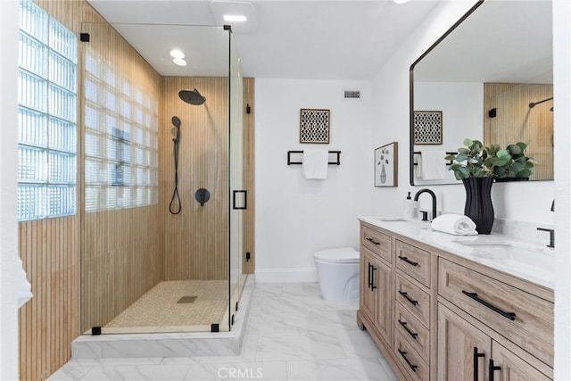 bathroom featuring a shower with door, vanity, a healthy amount of sunlight, and toilet