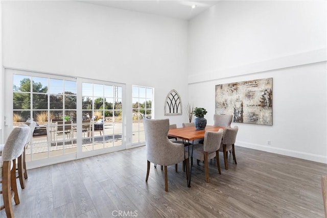 dining room featuring hardwood / wood-style flooring and high vaulted ceiling