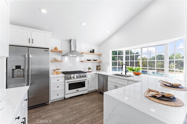 kitchen featuring dark hardwood / wood-style flooring, high end appliances, sink, wall chimney range hood, and white cabinets