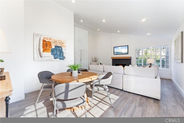 dining area featuring lofted ceiling and light wood-type flooring