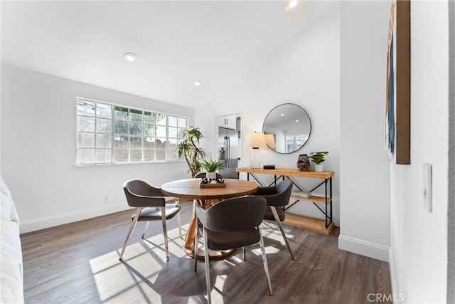 dining room with dark hardwood / wood-style flooring and vaulted ceiling