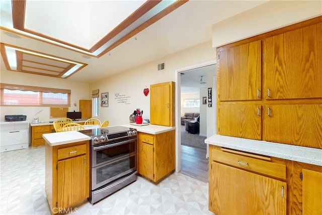 kitchen featuring kitchen peninsula and stainless steel range with electric cooktop